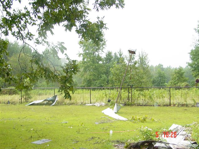 Bird house pushed to an angle, debris in the yard.